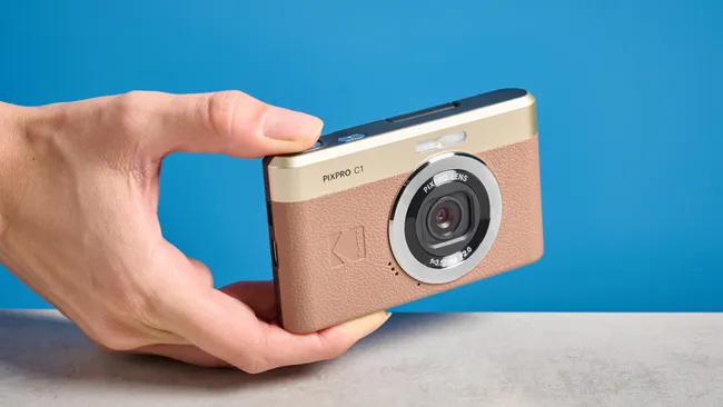 kodak compact camera PIXPRO C1 retro compact digital camera with brown and gold design held in hand